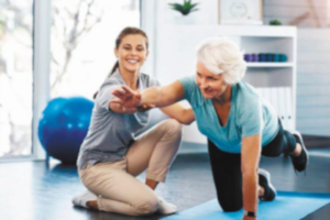 entrenadora ayudando a adulta mayor
