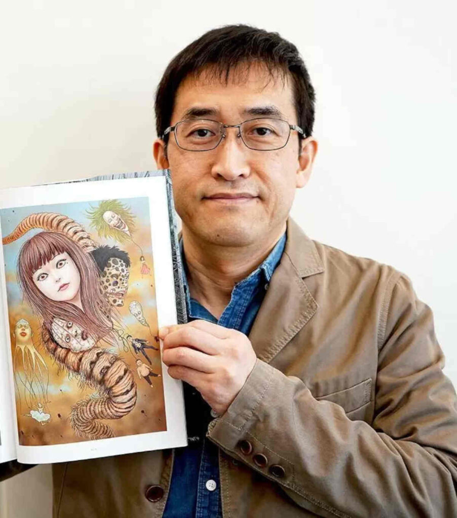 El mangaka japonés Junji Ito sostiene uno de sus libros de arte. el cual recopila ilustraciones basadas en unos de sus mangas y historias cortas.