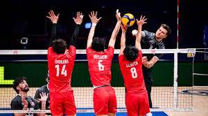 3 jugadores de voley saltando con las manos arriba frente a la red