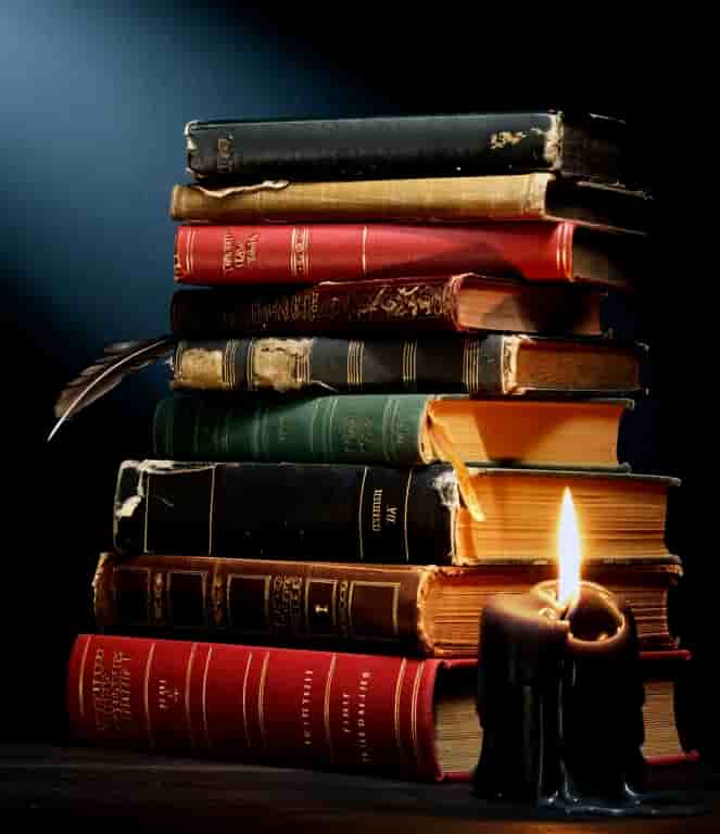 Pila de libros a la luz de una vela